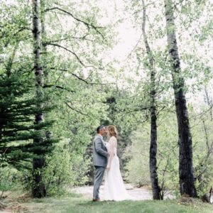 couple kissing in the forest in outdoor wedding