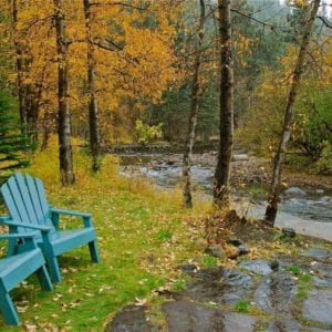 fall scenery with chairs by the river
