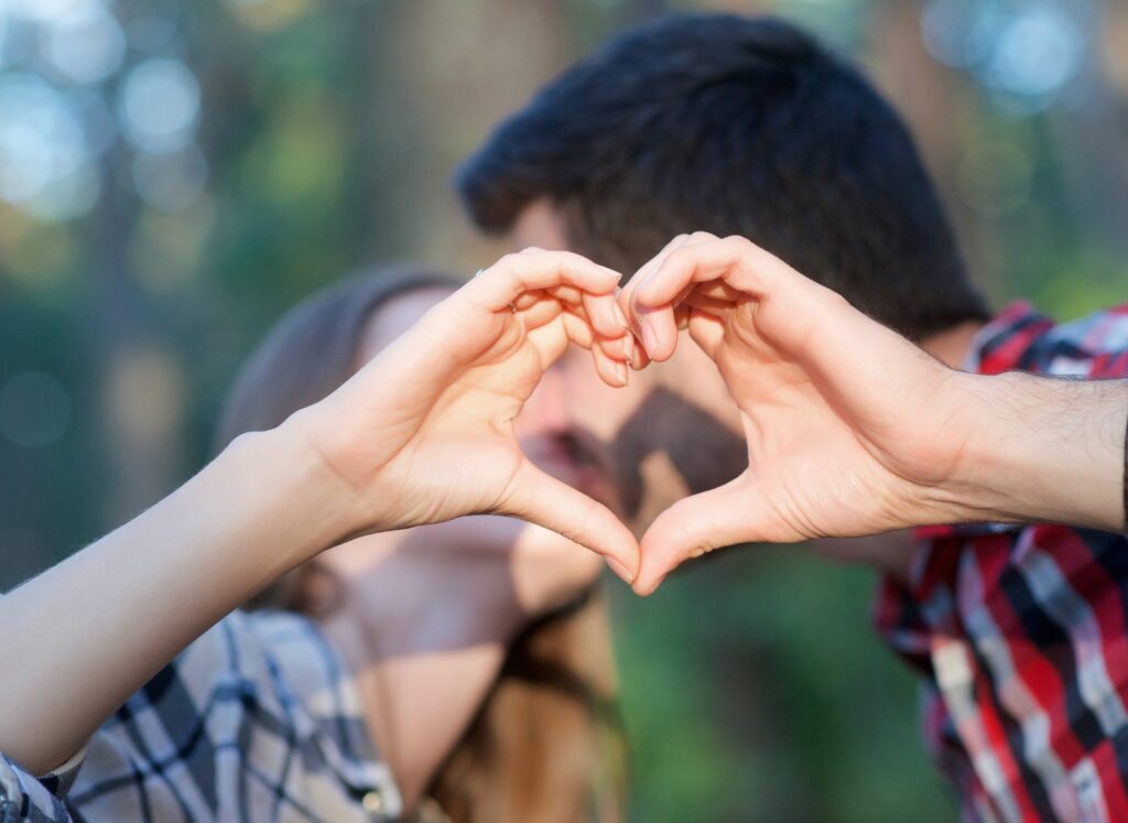 couple kissing doing hearts with hands on 7 benches trail